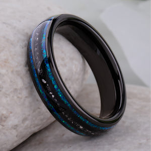 Black domed tungsten wedding ring with genuine meteorite center inlay and shimmering green-blue opal side inlays.