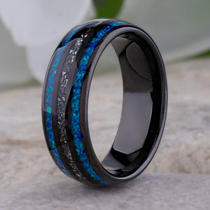 Black domed tungsten wedding ring with genuine meteorite center inlay and shimmering green-blue opal side inlays.