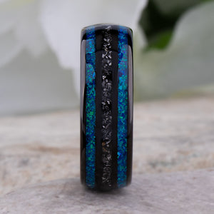 Black domed tungsten wedding ring with genuine meteorite center inlay and shimmering green-blue opal side inlays.