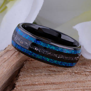 Black domed tungsten wedding ring with genuine meteorite center inlay and shimmering green-blue opal side inlays.