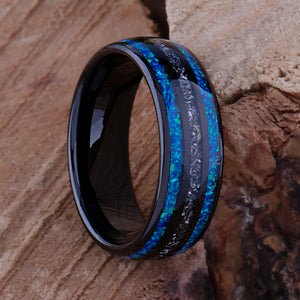 Black domed tungsten wedding ring with genuine meteorite center inlay and shimmering green-blue opal side inlays.