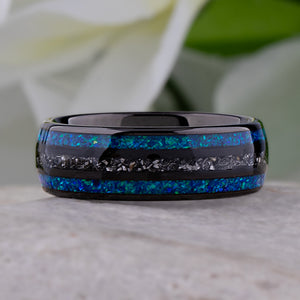 Black domed tungsten wedding ring with genuine meteorite center inlay and shimmering green-blue opal side inlays.