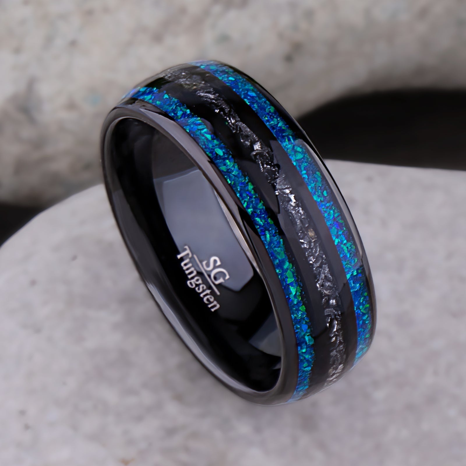Black domed tungsten wedding ring with genuine meteorite center inlay and shimmering green-blue opal side inlays.