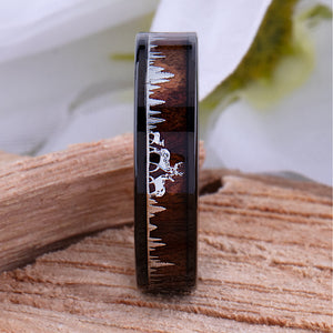 Tungsten ring with Deer design on a rosewood surface